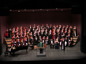 Mezzo-soprano Michelle Cipollone (standing) sings, with tenor Ricardo Garcia and soprano Katie Harman Ebner seated beside her during performance of 5th movement (Sanctus) of of Joseph Julian Gonzalez's Misa Azteca during Rogue Valley Chorale's Misa Azteca Concert, March 12, 2016 at Craterian Theatre, Medford, OR 